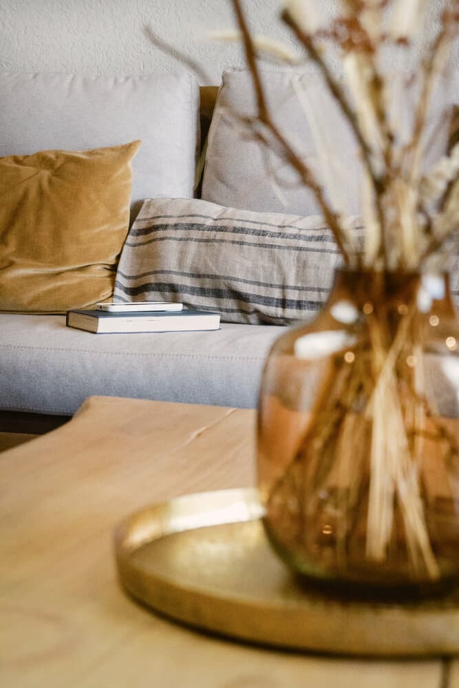 Rincón de living con flores secas sobre la mesa
