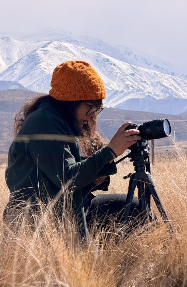 Rita Carrizo fotografiando frente a la cordillera